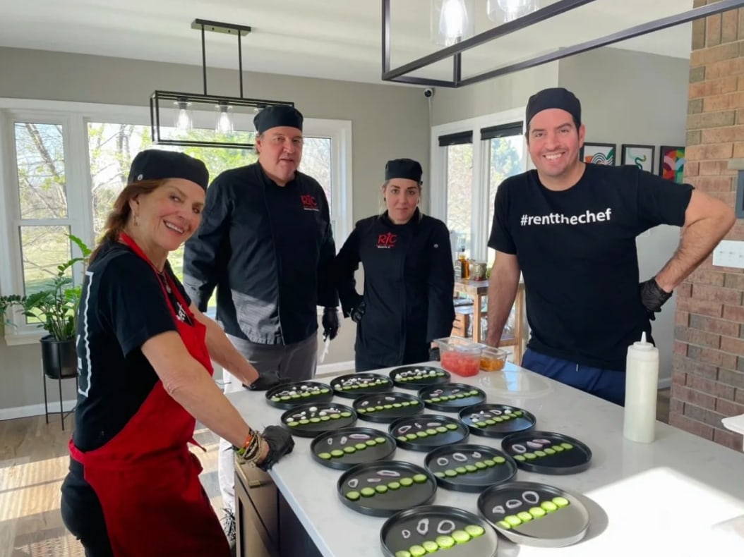 Chef Jason Febres and family plating a row of appetizers in a home kitchen